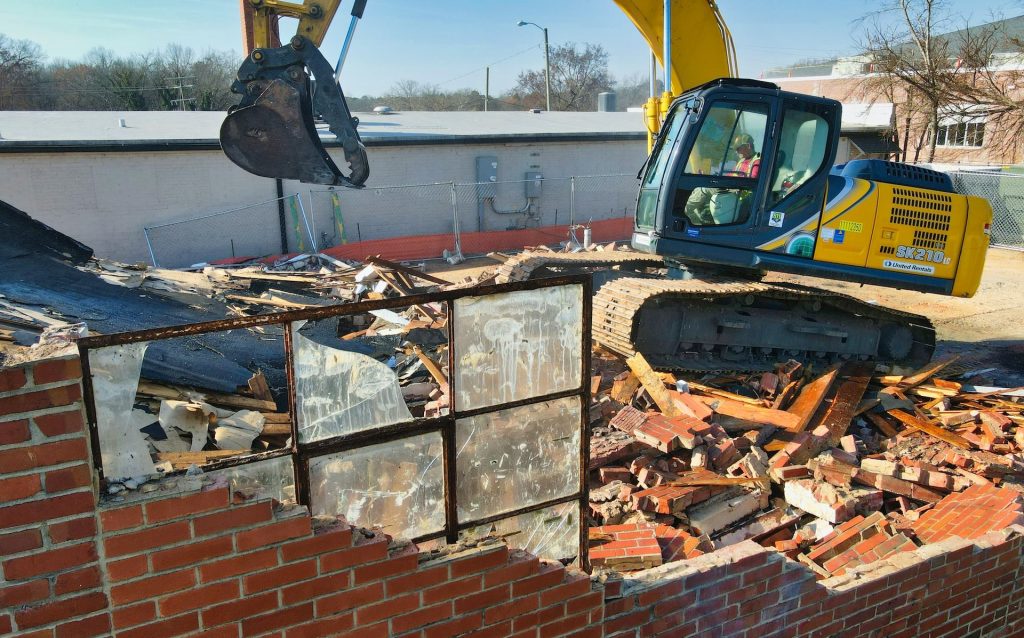 yellow and black excavator on brown brick wall during daytime